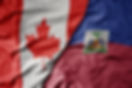 big waving realistic national colorful flag of canada and national flag of haiti . macro.j