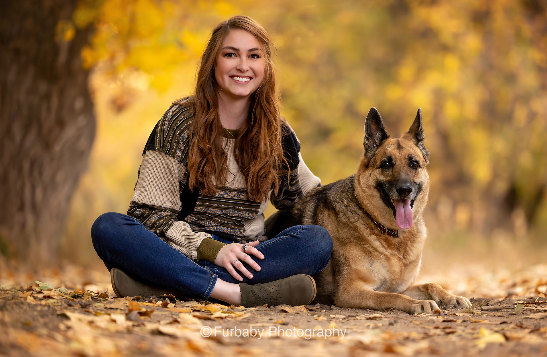 Young woman with german shepherd dog on fall trail smiling joyfully