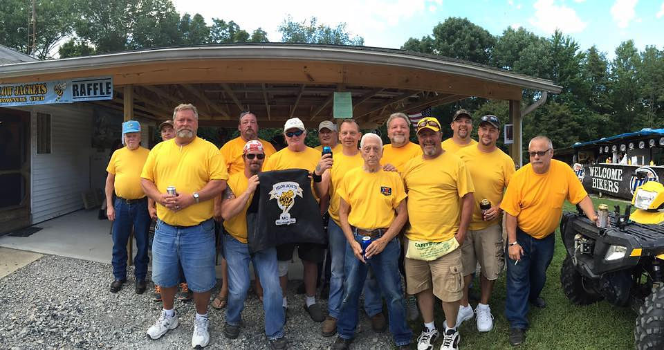 Motorcyclist family group gathered outdoors in yellow shirts