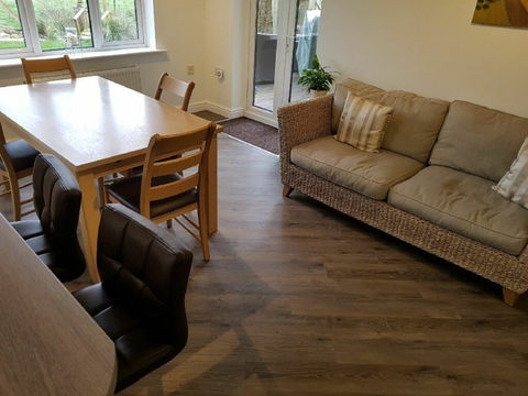 Dining table and chairs next to a sofa in a living room.
