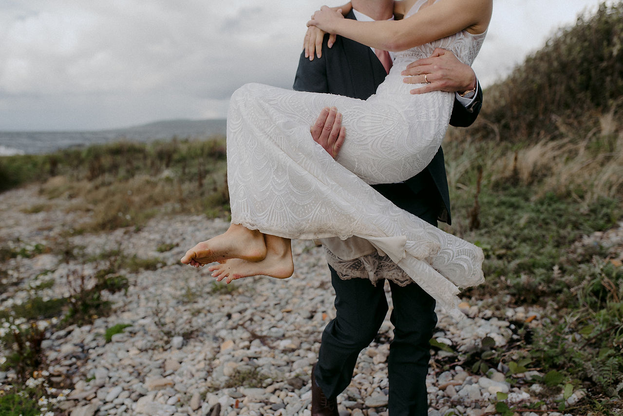 groom carrying bride candid
