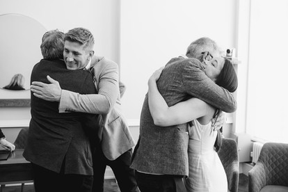 bride and groom hugging family at islington town hall wedding