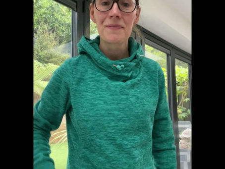 a lady in a green top doing breathing exercises