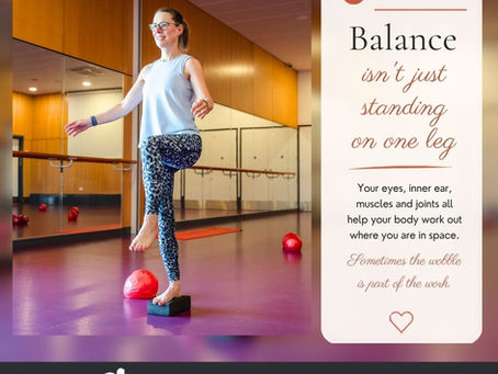 Woman balancing on one leg in a mirrored studio beside a Pilates Pointer poster reading Balance isn’t just standing on one leg.