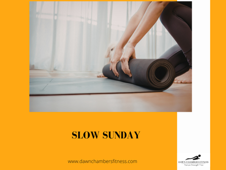 Person rolling up a yoga mat in a bright room, with orange border. Text reads "Slow Sunday" and "www.dawnchambersfitness.com."
