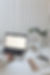 a scene with a laptop, pens, book, reading glasses, a cup of coffee and a plant. Someone is touching the mousepad of the laptop.