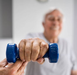 A senior engages in strength training with a dumbbell as part of a comprehensive wellness program, showcasing the supportive and personalized approach at Private Therapy Services in Charleston and Mount Pleasant.
