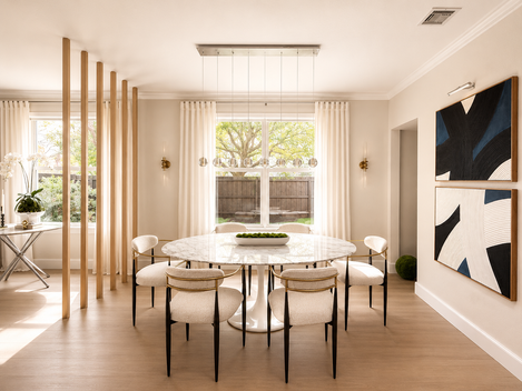 Contemporary dining room with sculptural furnishings, modern artwork, soft neutral tones, and architectural wood detailing.