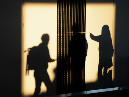 Siluetas difuminadas tras un cristal y superficies luminosas como símbolo del lenguaje, la percepción y la distancia social.