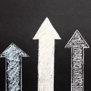 Varias flechas dibujadas con tiza apuntando hacia arriba, como símbolo de distintos caminos y funciones en la expansión entre Alemania y España.
