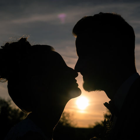 Silhouette de couple de mariés en contre-jour – baiser au coucher du soleil à La Rochelle, photo artistique
