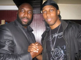 Two men smiling and shaking hands at an evening function