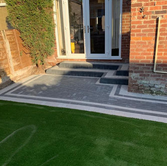 Contemporary patio and artificial grass garden area