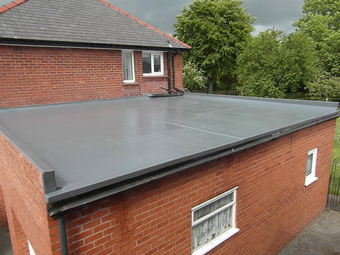 Smooth grey rubber flat roof installation on a modern brick home extension