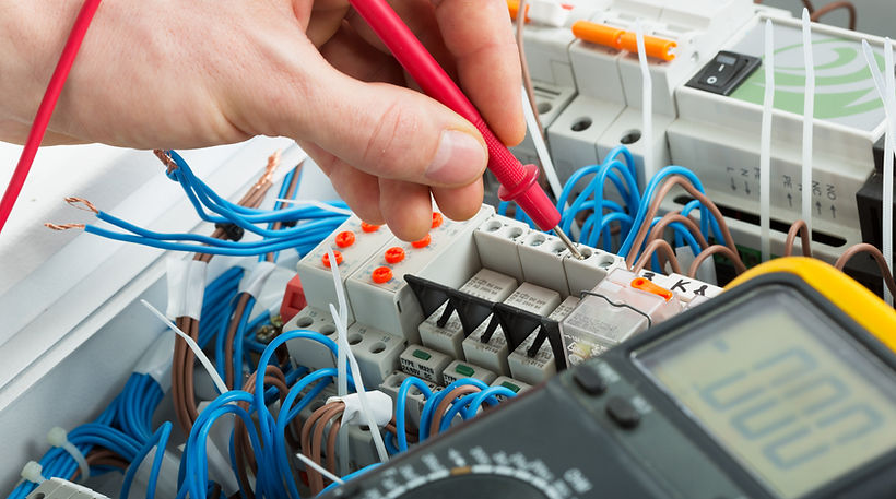 Hand testing complex electrical circuit wires with a pink probe for fault diagnosis in Horsham