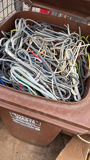Brown plastic waste bin filled with miscellaneous household rubbish