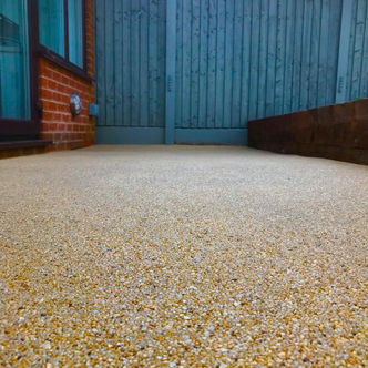 Resin-bound aggregate driveway beside blue garage doors