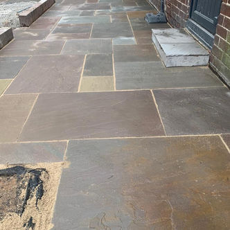 Large sandstone patio with contrasting dark edging