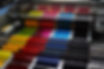 Close up view of colorful paper sheets feeding quickly through a commercial industrial printing press roller system