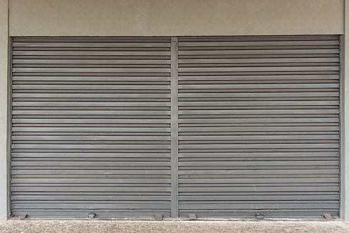 Closed gray metal roller shutter with horizontal slats, dividing line in the center