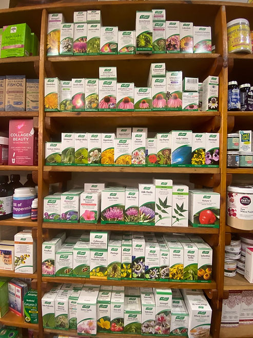 Bright wooden shelving unit neatly organized with various boxed health supplements and herbal remedies