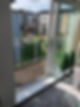 View from an apartment showing a balcony with metal railing with glass door