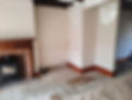 Interior room renovation with bare plaster walls and an open fireplace undergoing damp treatment