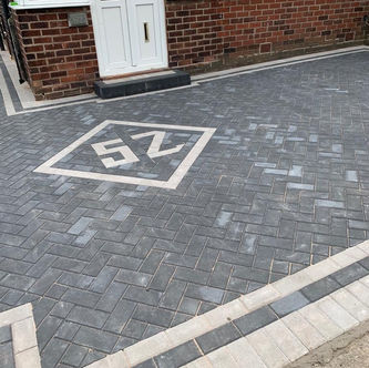 Grey block paved driveway with house number feature
