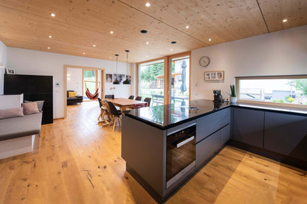Contemporary kitchen and dining room with wooden flooring and ceiling spotlights