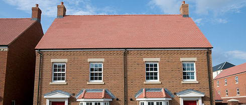A red door stands prominently on the front of a brick house, adding a vibrant touch to the exterior