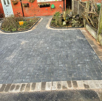 Grey block paved driveway with decorative border