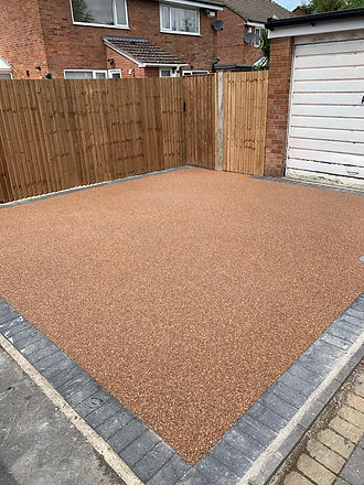 A driveway featuring brown paving stones arranged in a neat pattern