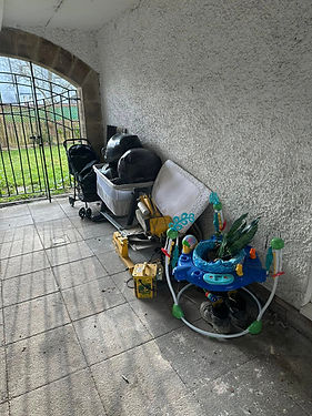 A baby stroller and a baby swing are placed on a porch, ready for outdoor playtime with a little one