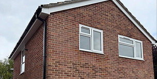 White double glazed casement windows on a red brick two storey house