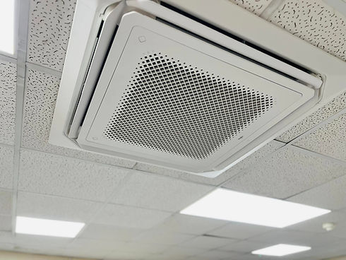Close up of a modern square ceiling cassette air conditioner installed in an office grid ceiling
