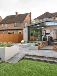 Modern backyard with a grassy lawn and paved patio