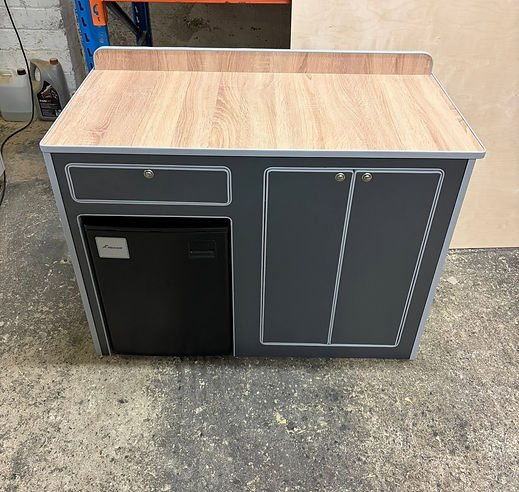 Freestanding dark grey kitchen pod with a light wood worktop and a built-in small fridge unit