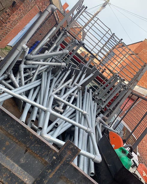 A pile of silver galvanised steel structural beams and metal framework on a construction site