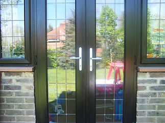 Glass patio doors with dark frames reflecting a garden view