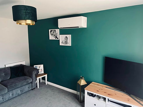 Modern living room with a white air conditioning unit mounted on a dark teal feature wall