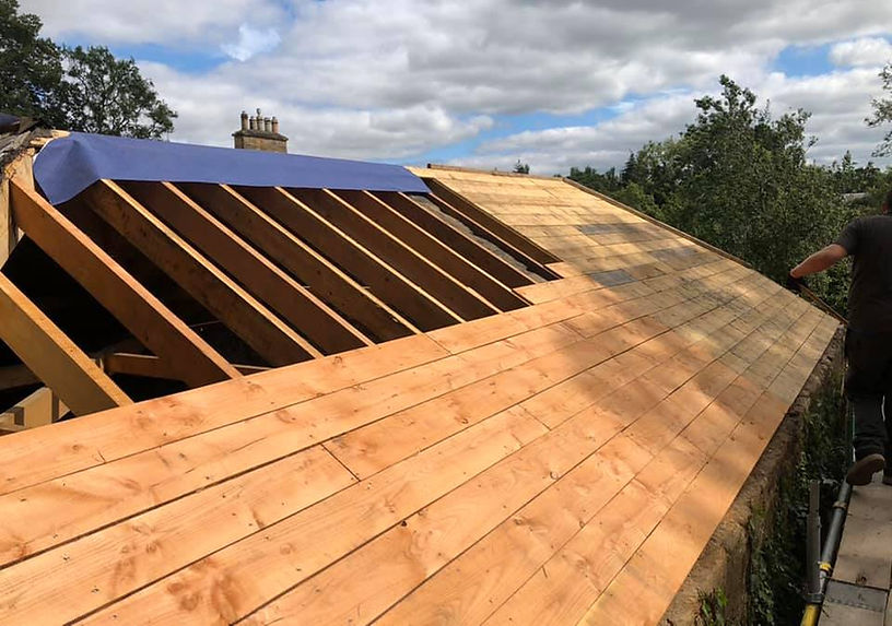Wooden roof under construction with visible beams and partially installed panels