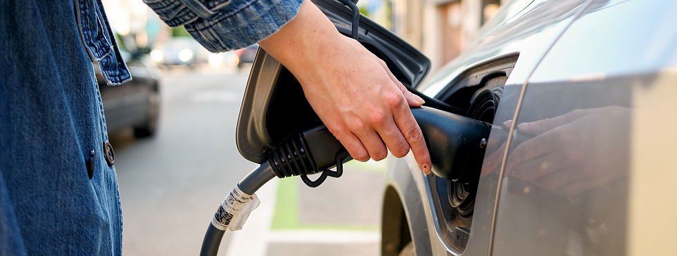 Close-up of a person plugging a charger cable into an electric vehicle