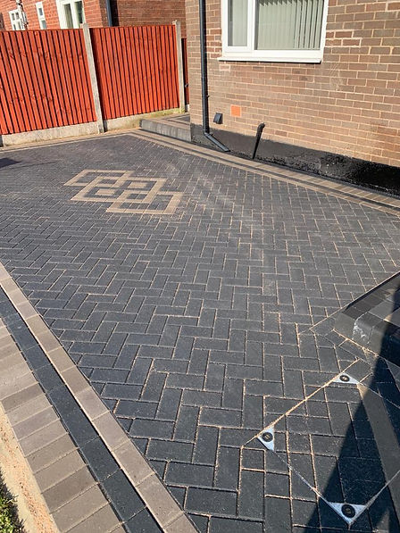 A driveway featuring a distinctive brick pattern, showcasing a blend of colors and textures