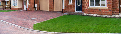 A brick house with a well-maintained driveway leading up to the entrance