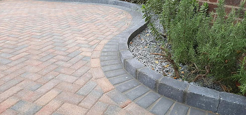 A brick patio featuring a stone wall and a brick walkway, creating a cozy outdoor space