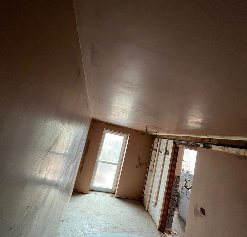 Empty room with brown walls and an exposed, dusty floor