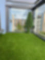 A small balcony with artificial grass flooring