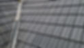 A close-up view of a building's roof featuring a sleek, modern metal roofing system