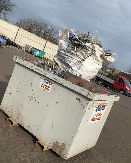Large white industrial waste skip in an outdoor yard with a white swan perched on top under a cloudy sky