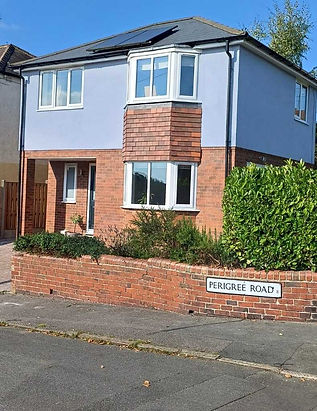 A modern two-story house with light blue walls and red brick accents